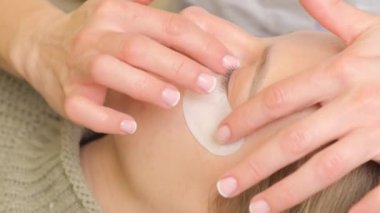 Güzellik salonunda kirpik boyama prosedürü. Modellerin göz kapakları, kirpikleri boyama süreci.