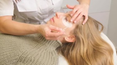 Güzellik salonunda kirpik boyama prosedürü. Modellerin göz kapakları, kirpikleri boyama süreci.