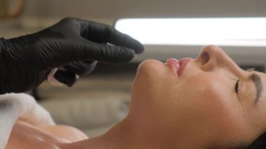 Kadın çenesi yakınındaki şırınga, çene şekli düzeltmesi için doldurulmuş güzellik iğneleri..