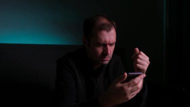 Haberleri akıllı telefonundan okuyan bir adam haberleri merak eder..