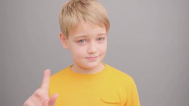 Sarı tişörtlü çocuk hayır diyor ve parmağını gösteriyor..