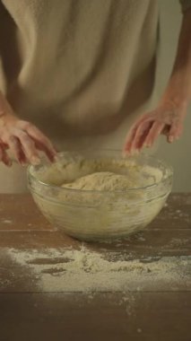 Pizza ve ekmek yapmak için hamur yoğuran kadın. Dikey video.