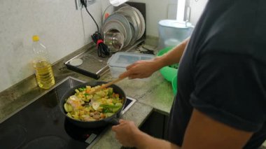 Et ve sebzeler kızartma tavasında cızırdar ve pişirir..