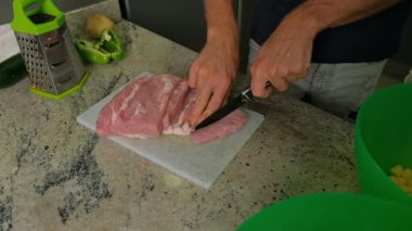 Mutfakta et kesen bir adamın yakın çekimi..