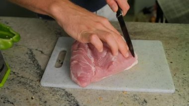 Mutfakta et kesen bir adamın yakın çekimi..