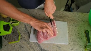 Mutfakta et kesen bir adamın yakın çekimi..