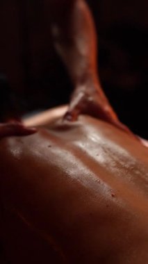 Spa salonunda masaj yaptıran bir kadın. Masör sırtında çalışıyor..