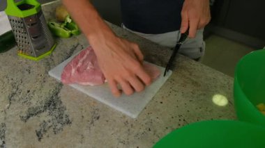 Mutfakta et kesen bir adamın yakın çekimi..