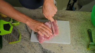 Mutfakta et kesen bir adamın yakın çekimi..