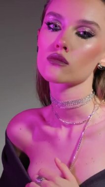 Siyah pullu bir kızın güzel portresi. Dikey video.