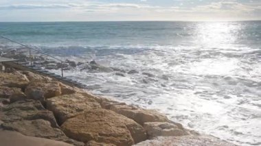 Deniz dalgaları taşların üzerinde yuvarlanıyor