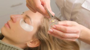 Güzellik salonunda kirpik boyama prosedürü. Modellerin göz kapakları, kirpikleri boyama süreci.