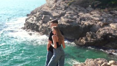 Deniz kenarında keyifle romantik bir anın tadını çıkaran bir çift aşkın ve doğanın özünü yakalıyor.