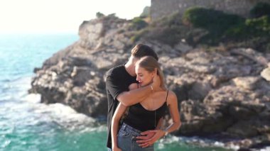 Deniz kenarında keyifle romantik bir anın tadını çıkaran bir çift aşkın ve doğanın özünü yakalıyor.