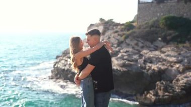 Deniz kenarında keyifle romantik bir anın tadını çıkaran bir çift aşkın ve doğanın özünü yakalıyor.