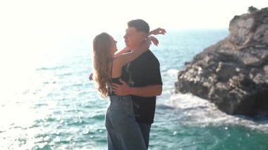 Deniz kenarında keyifle romantik bir anın tadını çıkaran bir çift aşkın ve doğanın özünü yakalıyor.