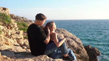 Deniz kenarında keyifle romantik bir anın tadını çıkaran bir çift aşkın ve doğanın özünü yakalıyor.