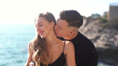 Deniz kenarında keyifle romantik bir anın tadını çıkaran bir çift aşkın ve doğanın özünü yakalıyor.