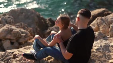 Deniz kenarında keyifle romantik bir anın tadını çıkaran bir çift aşkın ve doğanın özünü yakalıyor.