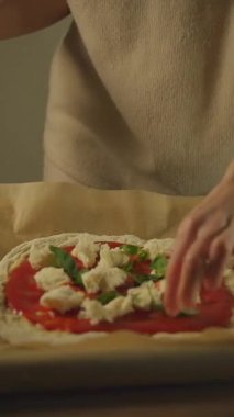 Hamur ve domates ezmesine fesleğen yaprağı koyarak lezzetli pizza yapmak..