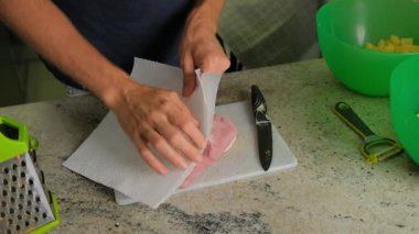 Becerikli bir şef eti kağıt havlularla kurutur. Temiz bir kesim tahtasıyla, aşçılık yeteneklerini sergiliyor.