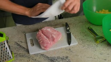 Becerikli bir şef eti kağıt havlularla kurutur. Temiz bir kesim tahtasıyla, aşçılık yeteneklerini sergiliyor.