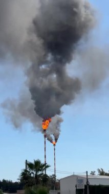 Kimya fabrikasındaki bacadan siyah duman. Atmosfere zararlı maddelerin çevresel kirliliği.