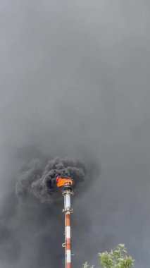 Kimya fabrikasındaki bacadan siyah duman. Atmosfere zararlı maddelerin çevresel kirliliği.