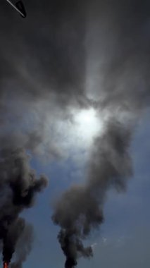 Kimya fabrikasındaki bacadan siyah duman. Atmosfere zararlı maddelerin çevresel kirliliği.