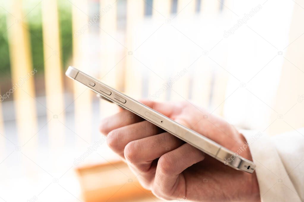 Tarragona, Spain - March 24, 2024: A man holds a new iPhone 15 pro in his hand.
