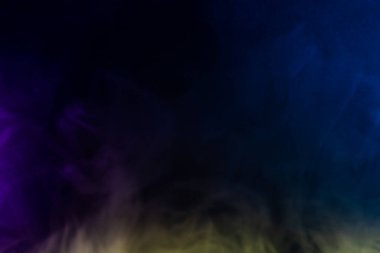 Siyah arkaplandaki renkli dumanın bulanık fotoğraf dokusu.