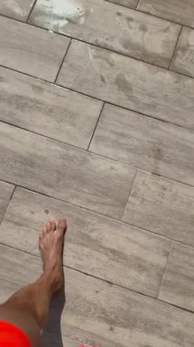 Havuza giren bir adam, en üst bacak manzarası..