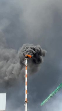 Kimya fabrikasındaki bacadan siyah duman. Atmosfere zararlı maddelerin çevresel kirliliği.