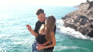 Deniz kenarında keyifle romantik bir anın tadını çıkaran bir çift aşkın ve doğanın özünü yakalıyor.