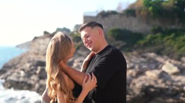 Deniz kenarında keyifle romantik bir anın tadını çıkaran bir çift aşkın ve doğanın özünü yakalıyor.