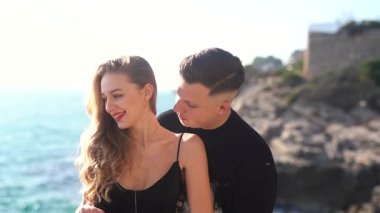 Deniz kenarında keyifle romantik bir anın tadını çıkaran bir çift aşkın ve doğanın özünü yakalıyor.