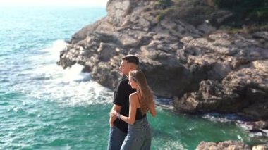 Deniz kenarında keyifle romantik bir anın tadını çıkaran bir çift aşkın ve doğanın özünü yakalıyor.