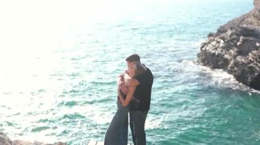 Deniz kenarında keyifle romantik bir anın tadını çıkaran bir çift aşkın ve doğanın özünü yakalıyor.