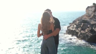 Deniz kenarında keyifle romantik bir anın tadını çıkaran bir çift aşkın ve doğanın özünü yakalıyor.