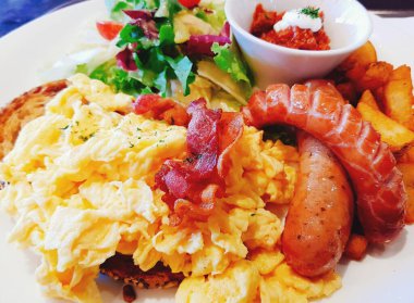 Kahvaltıda yumurta, pastırma, sosis, salata ve sebze