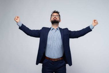 Mavi takım elbiseli neşeli bir İspanyol 'un yarı vücut portresi. Kolları ve kolları açık, geniş bir şekilde gülümsüyor. Onun ifadesi zafer, başarı ve motivasyon yayar. Başarı, liderlik ve iş konuları için mükemmel