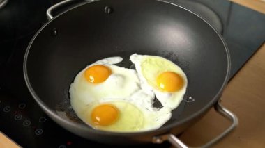 Elektrikli ocakta tavada üç yumurta kızartmak.
