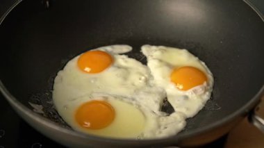 Elektrikli ocakta tavada üç yumurta kızartmak.
