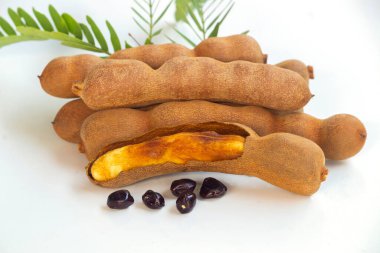 Closeup Tamarind fruits on white background , Half ripe Peeled tamarind clipart