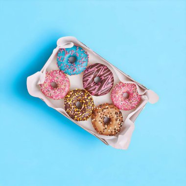 # Çikolata ve tatlı çöreklerle dolu # # parlak mavi arka planda bir çörek kutusuna serpiştirilmiş #