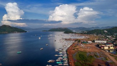 Sakin mavi sular ve yemyeşil dağlarla çevrili muhteşem bir kıyı kasabası manzarası. Liman çok sayıda geleneksel ve modern teknelerle dolup taşarken, çarpıcı bir şekilde parlayan gökyüzü...