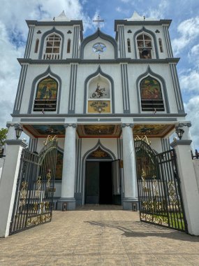 A stunning facade of a historical church featuring intricate details, arched windows, and religious artwork. The open gates invite visitors to explore its rich cultural and spiritual heritage under a clipart