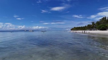 Filipinler, Panglao Adası 'nın beyaz kumlu plajı yakınlarındaki berrak sularda çarpıcı bir hava aracı uçuşu tropikal manzarayı, tekneleri ve sakin mavi gökyüzünü gözler önüne seriyor..