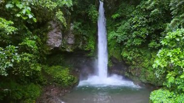 Filipinler, Camiguin 'de yoğun yeşil ormanlarla çevrili kayalık bir uçurumdan aşağı nefes kesici bir şelale düşer. Yükselen su sisli bir atmosfer yaratarak dinginliği ve dokunulmazlığı arttırır.