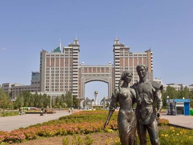 Geleneksel Kazak çiftinin bronz heykeli, Kazakistan 'ın Astana kentindeki KazMunayGaz merkezinin önünde duruyor. Kemer ve modern tasarımı ile birlikte anıtsal bina